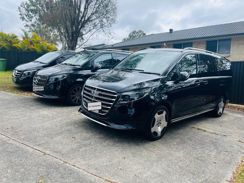 Three of our black Mercedes-Benz V-Class people movers on the driveway.